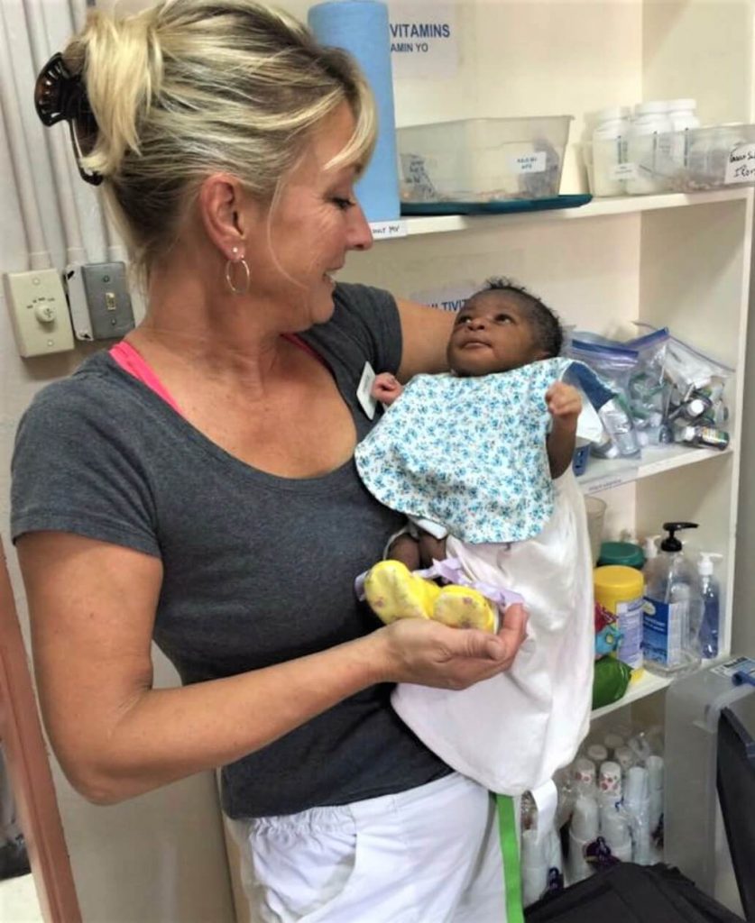 Jill Henderson bonding with a Haitian baby whose mother became ill